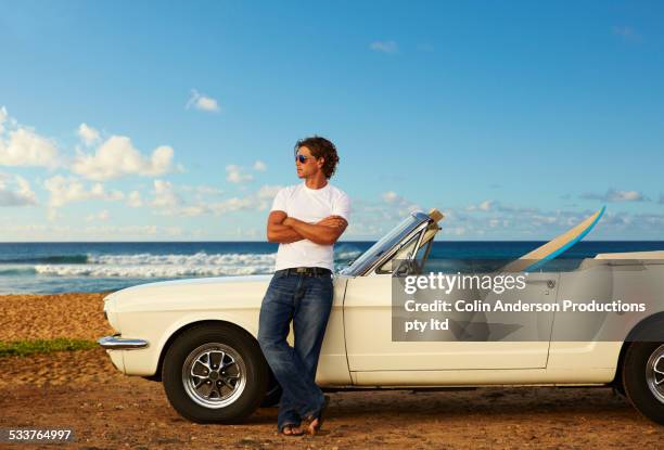 caucasian man relaxing on convertible on beach - classic day 1 bildbanksfoton och bilder