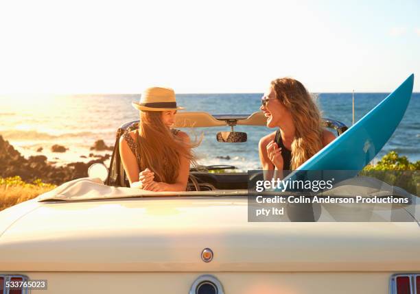 women relaxing in convertible on beach - hawaii fun fotografías e imágenes de stock