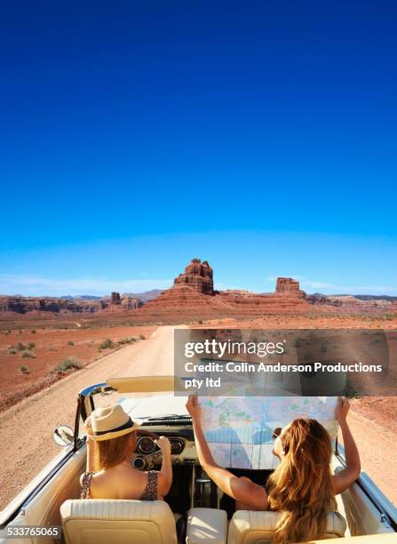 women reading map in convertible on remote road - road trip stock pictures, royalty-free photos & images