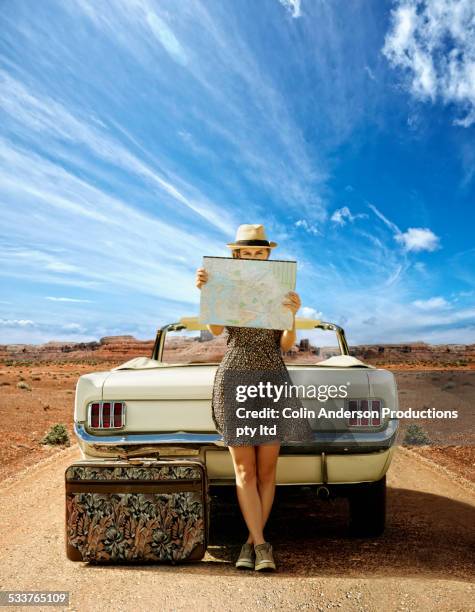 caucasian woman with convertible reading map on remote road - dried plant stock-fotos und bilder