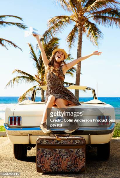 caucasian woman cheering on convertible on beach - hawaii fun fotografías e imágenes de stock
