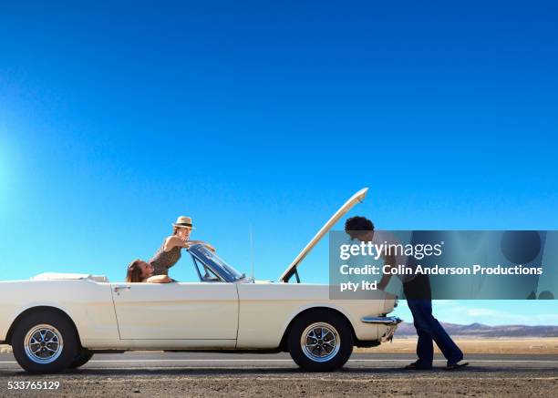 friends stranded with broken down convertible on remote road - vehicle breakdown stock pictures, royalty-free photos & images