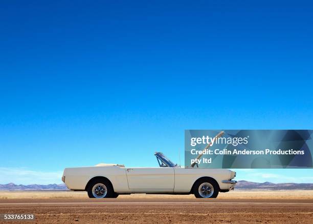 broken down convertible abandoned on remote road - landskap stockfoto's en -beelden