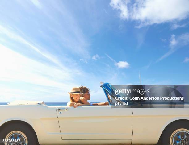 caucasian couple driving convertible under blue sky - driving car blue stock pictures, royalty-free photos & images