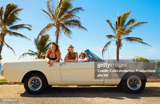 friends relaxing in convertible under palm trees - palm sunday stockfoto's en -beelden