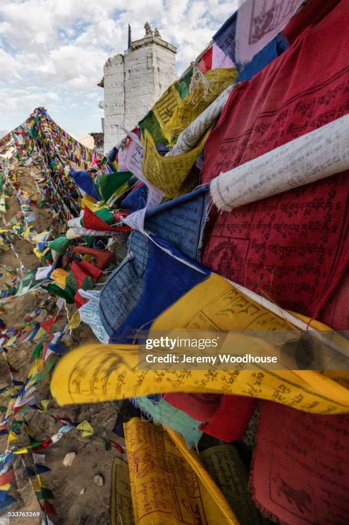 Low angle view of colorful prayer flags under hillside monastery, Leh, Ladakh, India