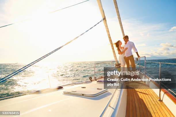 caucasian couple hugging on yacht deck - sail boat deck stock pictures, royalty-free photos & images