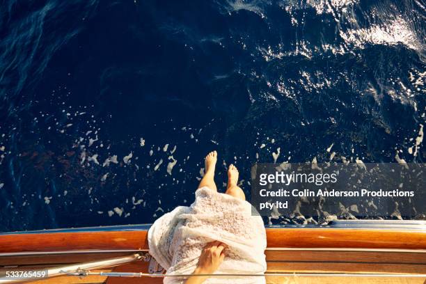 high angle view of caucasian woman dangling feet over boat deck - rico e anderson fotografías e imágenes de stock