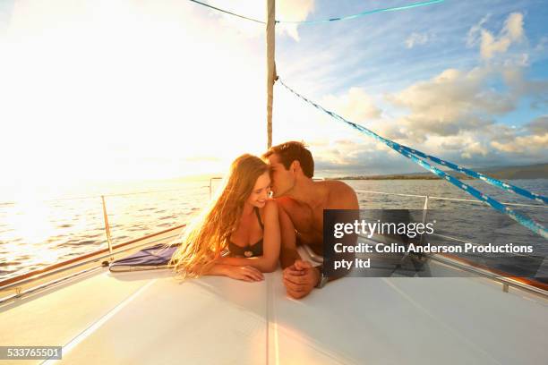 caucasian couple sunbathing on yacht deck - kiss booth stock-fotos und bilder