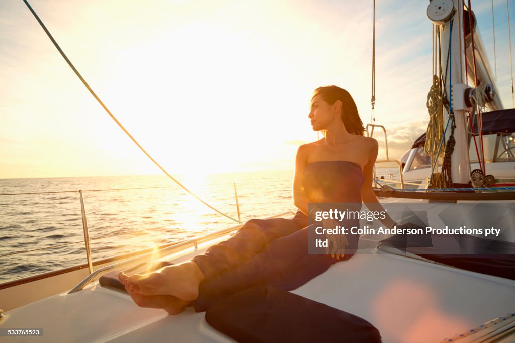 Asian woman sitting on yacht deck