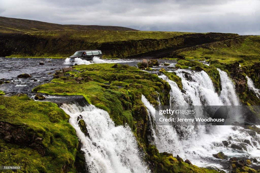 Waterfall flowing over rock formations in remote river