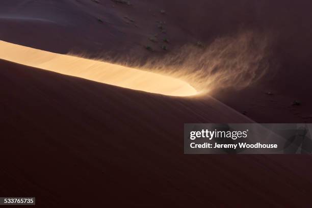 high angle view of sand blowing from sand dune in desert - dunes arena fotografías e imágenes de stock