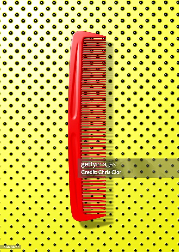 Close up of red comb on polka dot background