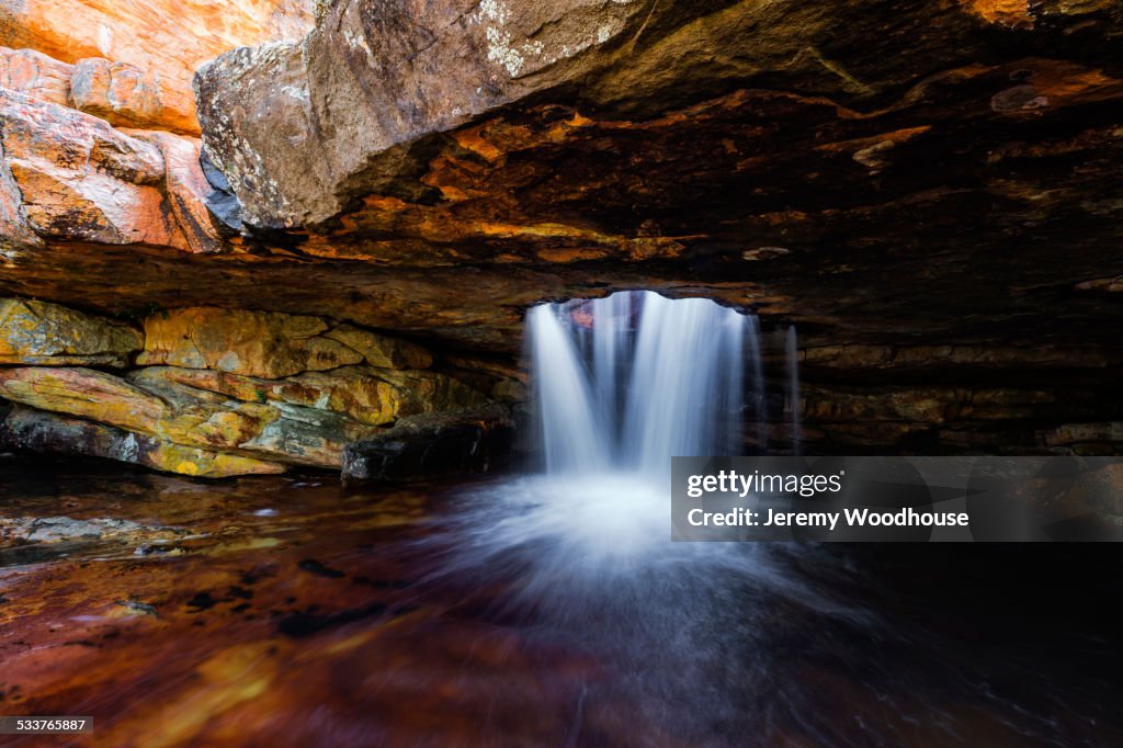 Time lapse view of waterfall flowing in rock cave