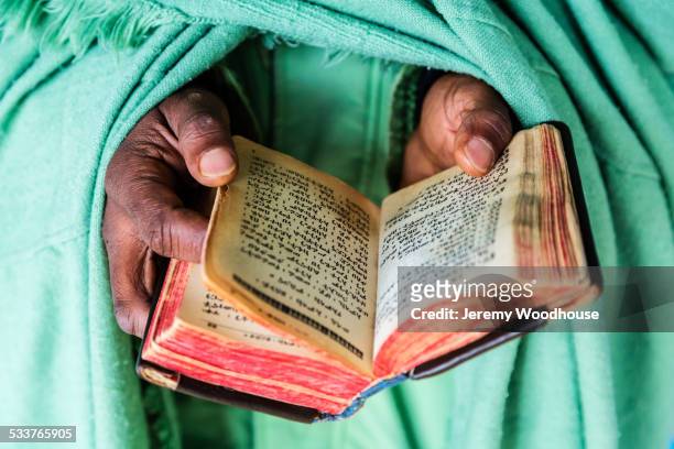 close up of hands of priest holding bible - pastor stock pictures, royalty-free photos & images