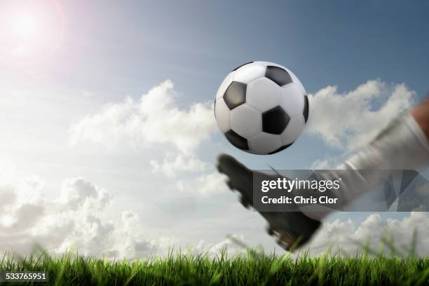 blurred view of foot kicking soccer ball - treten stock-fotos und bilder