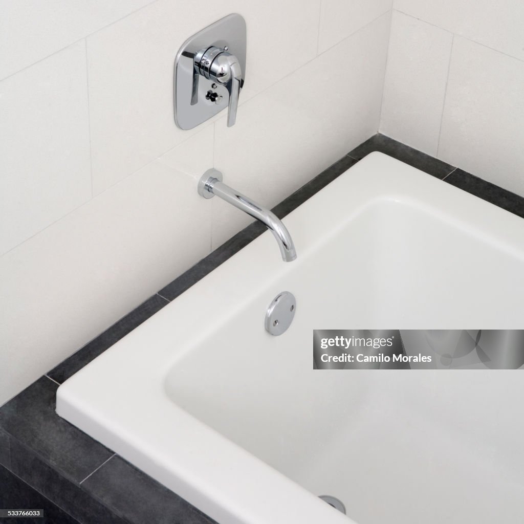 Close up of faucet and bathtub in modern bathroom