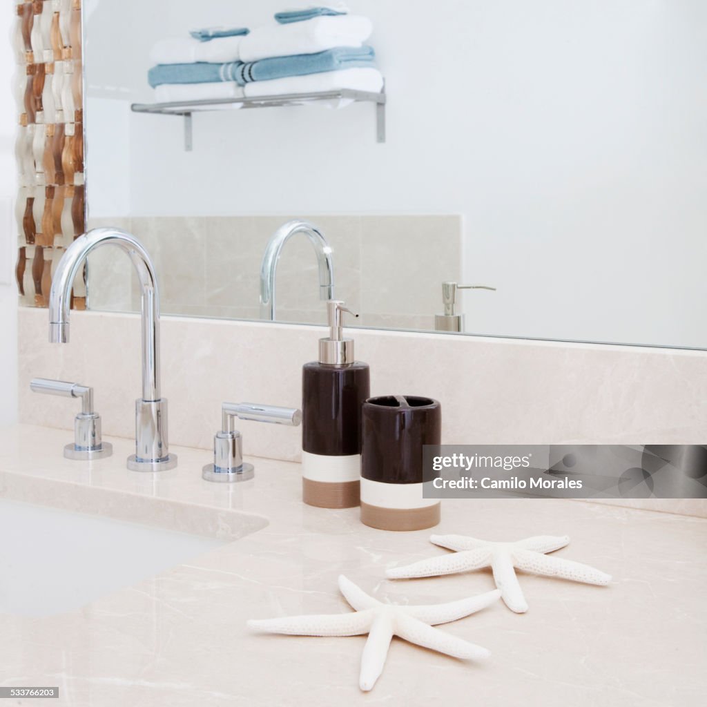 Close up of faucet, sink and mirror in modern bathroom