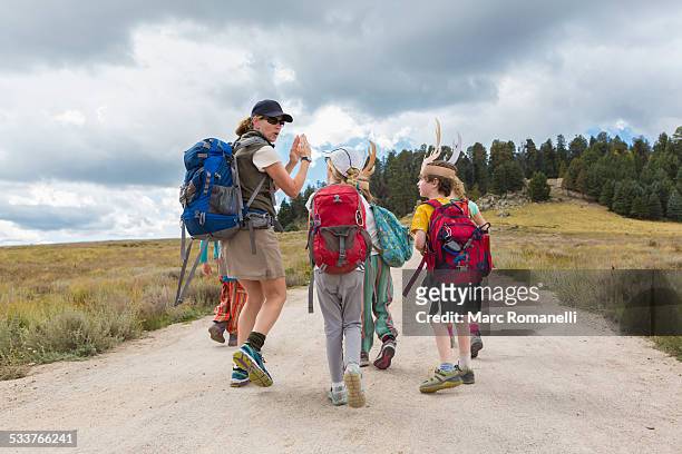 caucasian hiker leading children on path in remote landscape - teaching remotely stock pictures, royalty-free photos & images
