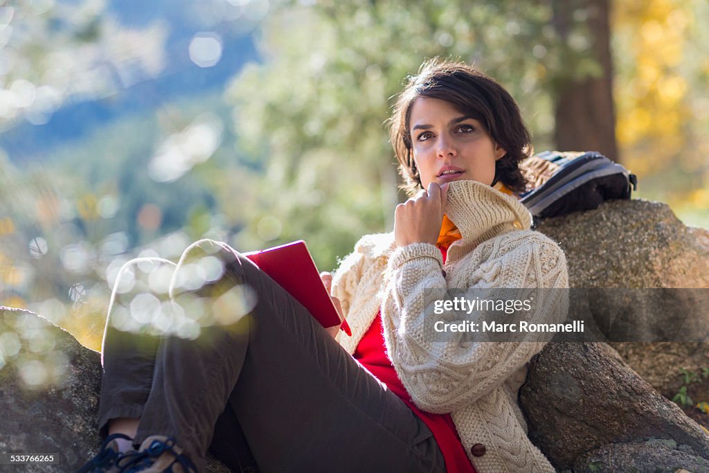 Mixed race hiker reading in forest