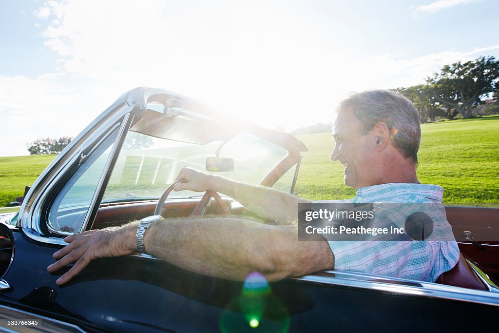 Caucasian man driving classic convertible