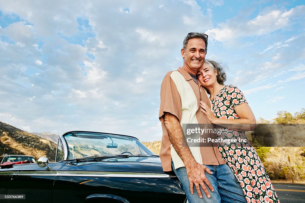 Couple smiling near classic convertible