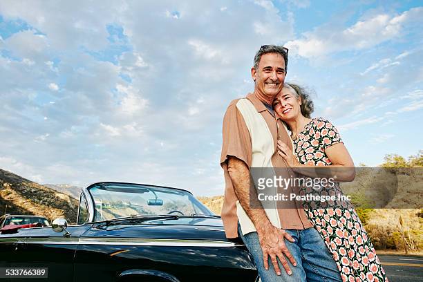 couple smiling near classic convertible - arab car stock pictures, royalty-free photos & images