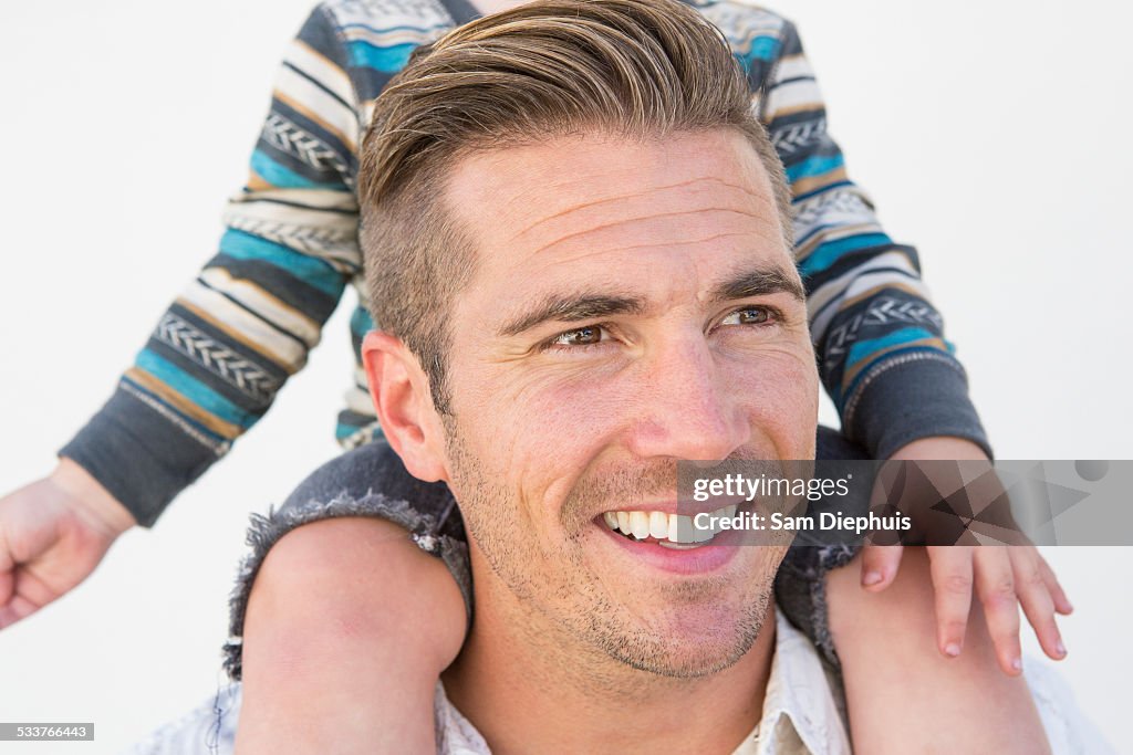 Close up of Caucasian father holding son on shoulders