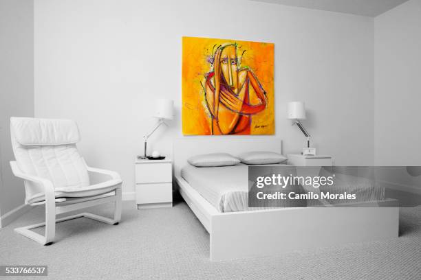 chair, wall art and bed in modern bedroom - headboard stockfoto's en -beelden