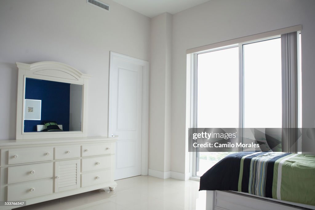 Dresser, mirror and windows in modern bedroom