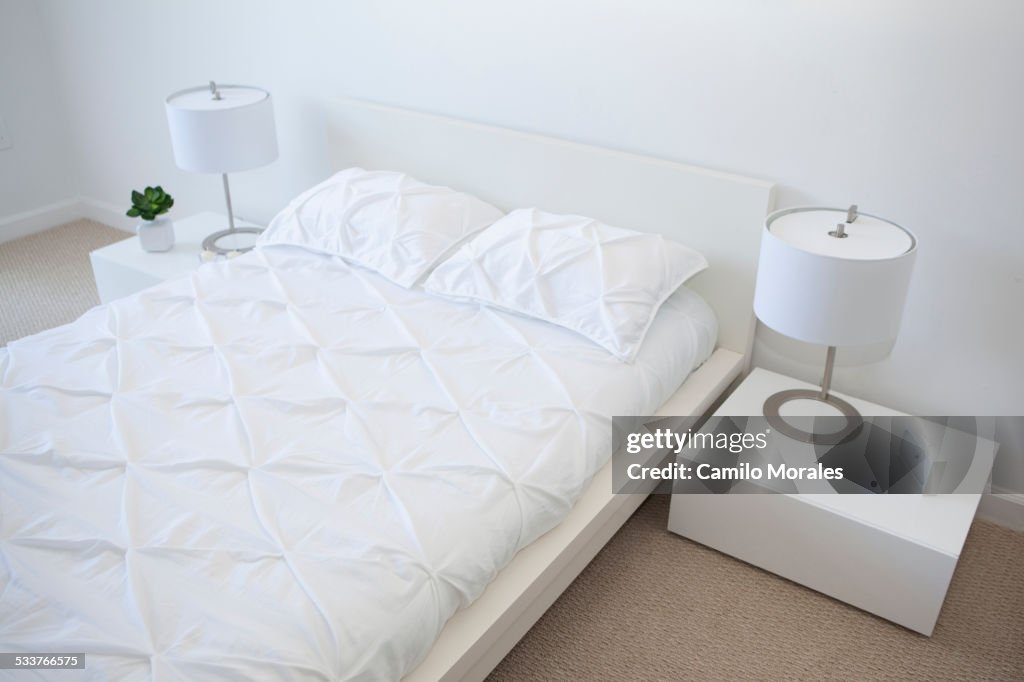 High angle view of bed and night tables in modern bedroom