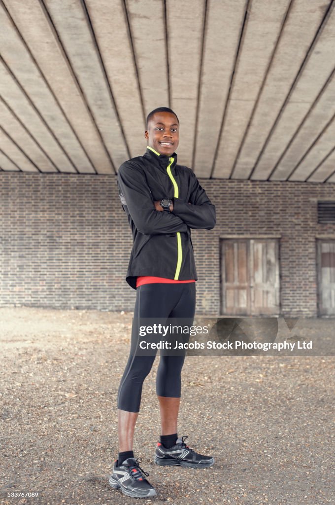 African American runner standing under concrete structure