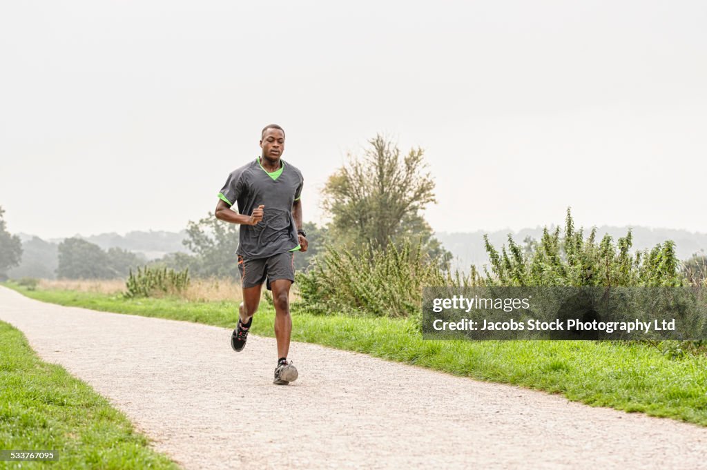 African American runner jogging on gravel path