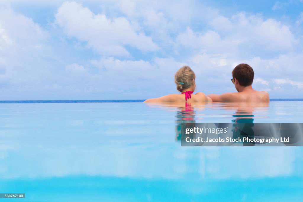 Caucasian couple relaxing in swimming pool