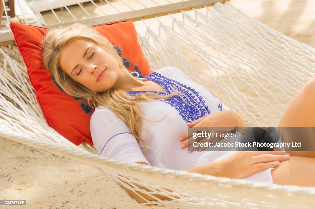 Caucasian woman napping in hammock