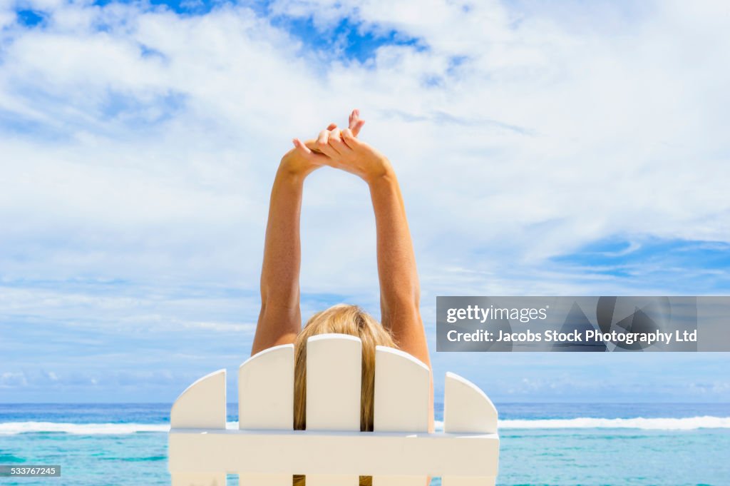 Caucasian woman stretching in adirondack chair