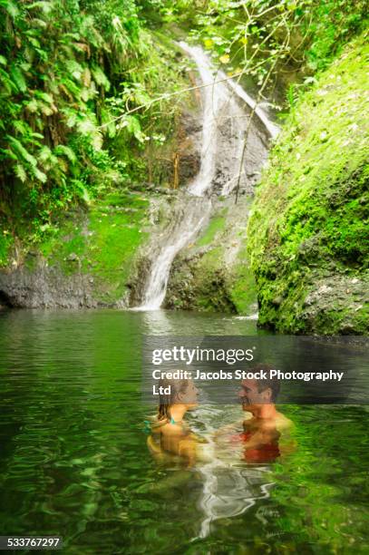 caucasian couple swimming in remote jungle pool - cook islands stock pictures, royalty-free photos & images