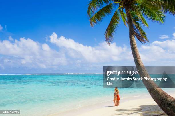 caucasian couple standing on tropical beach - rarotonga fotografías e imágenes de stock