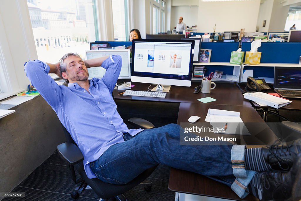 Businessman relaxing at desk in office