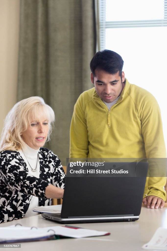 Teacher and student using laptop in meeting