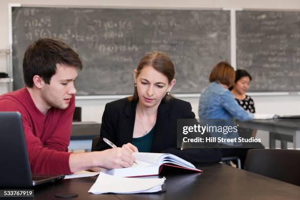 caucasian student and teacher studying in classroom - physics chalkboard stock pictures, royalty-free photos & images