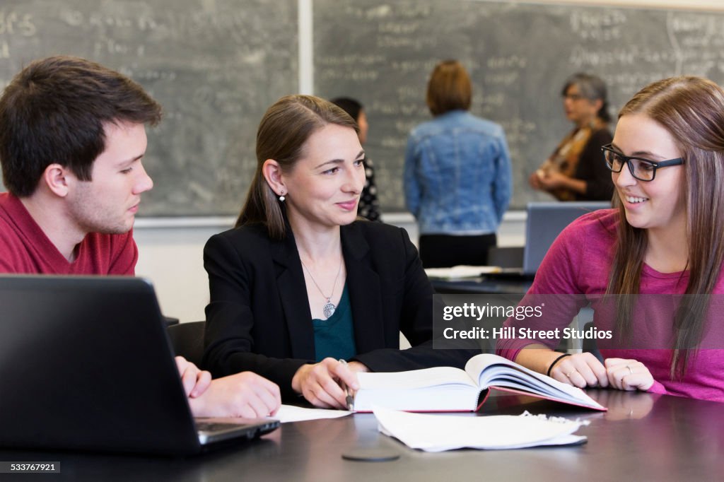 Caucasian students and teacher talking in classroom