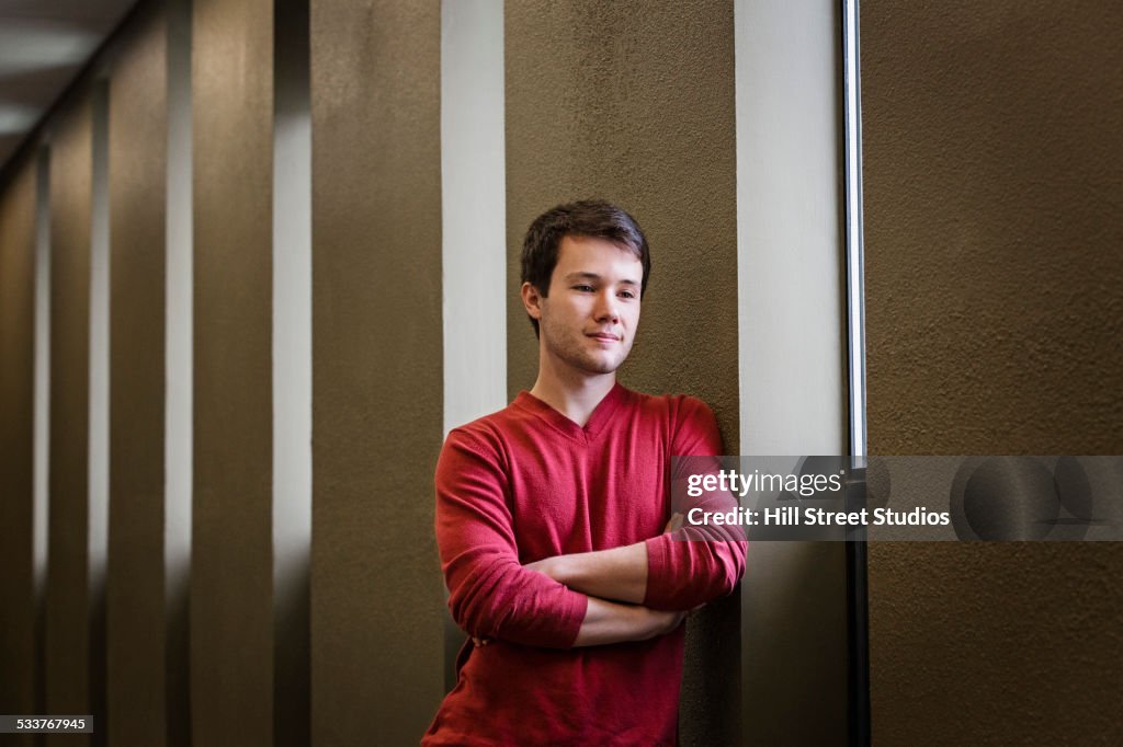 Caucasian man looking down near window