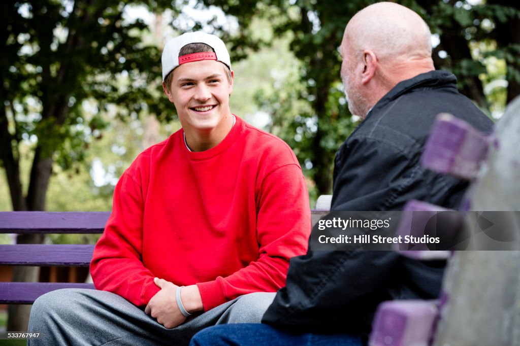 Student and teacher talking on park benches