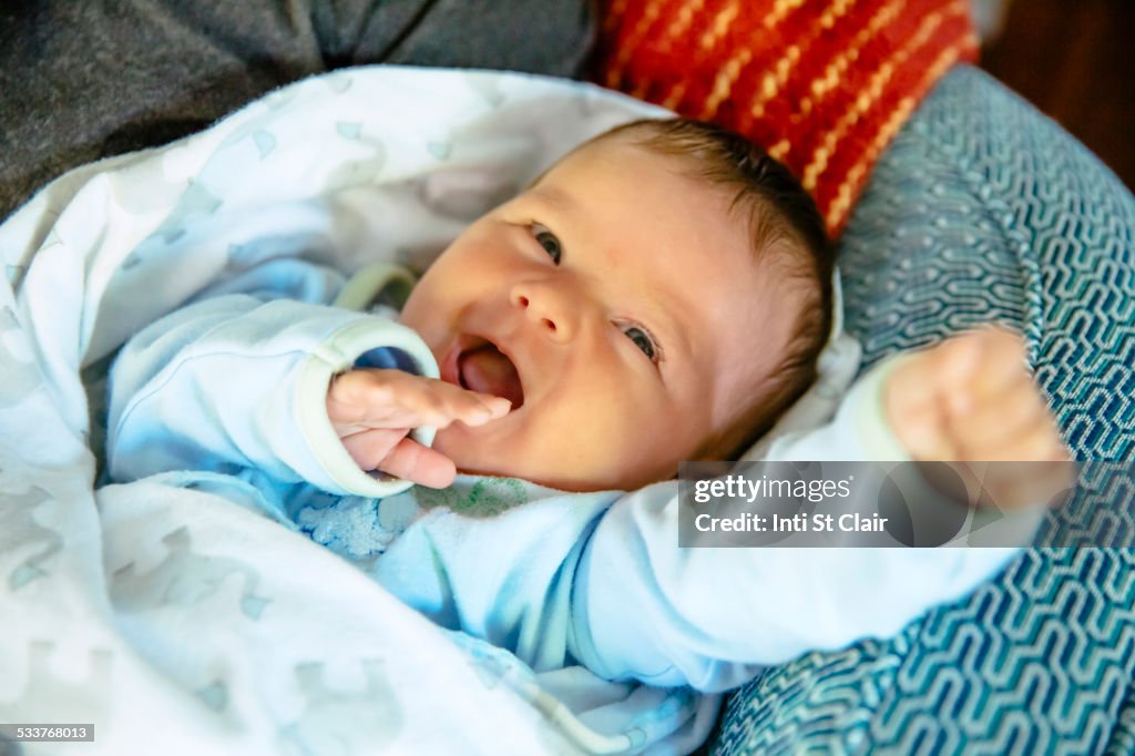 Caucasian baby boy laughing on sofa