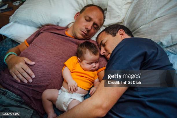Caucasian fathers and baby boy sleeping on bed