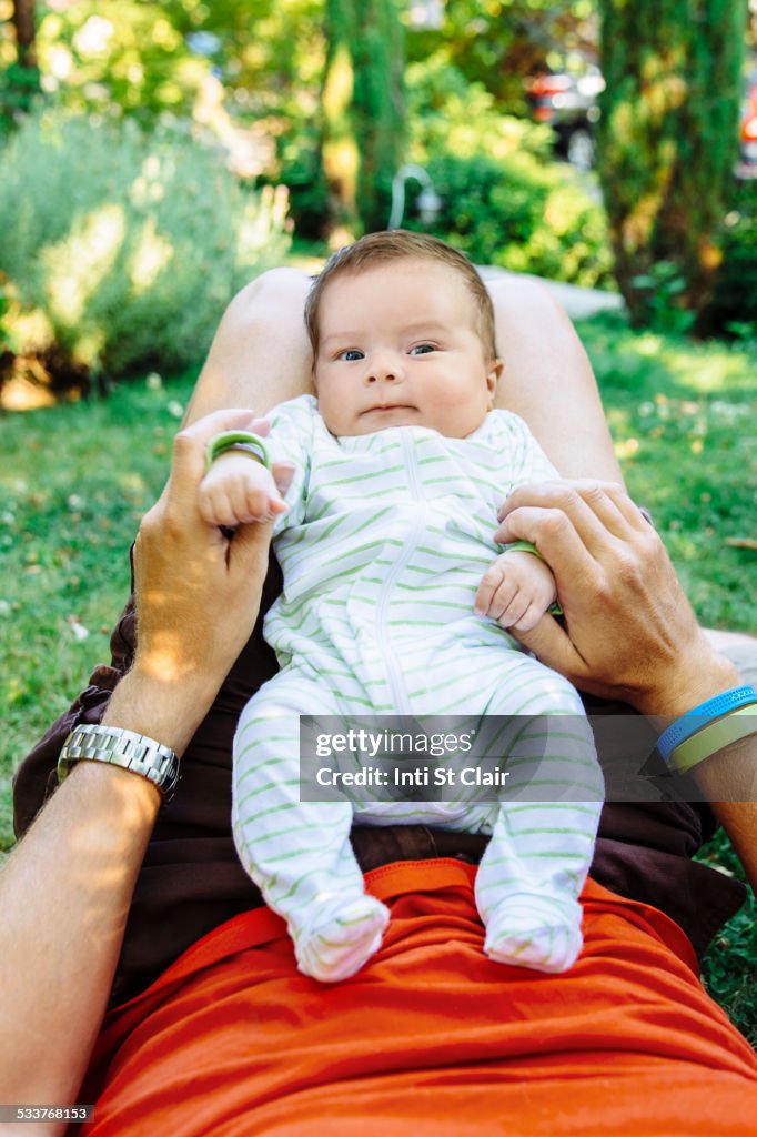 Caucasian father playing with baby boy in backyard