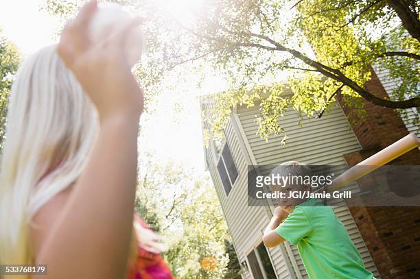 caucasian children playing baseball in backyard - backyard baseball stockfoto's en -beelden