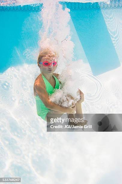 caucasian girl swimming underwater in pool - kanon stockfoto's en -beelden