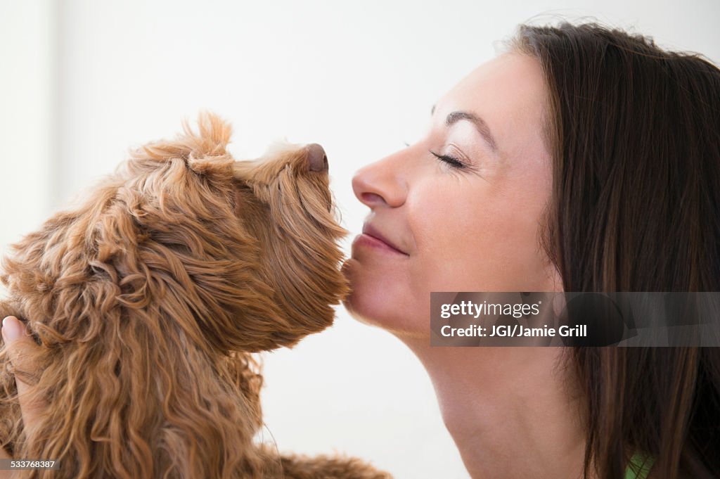Caucasian woman kissing pet dog